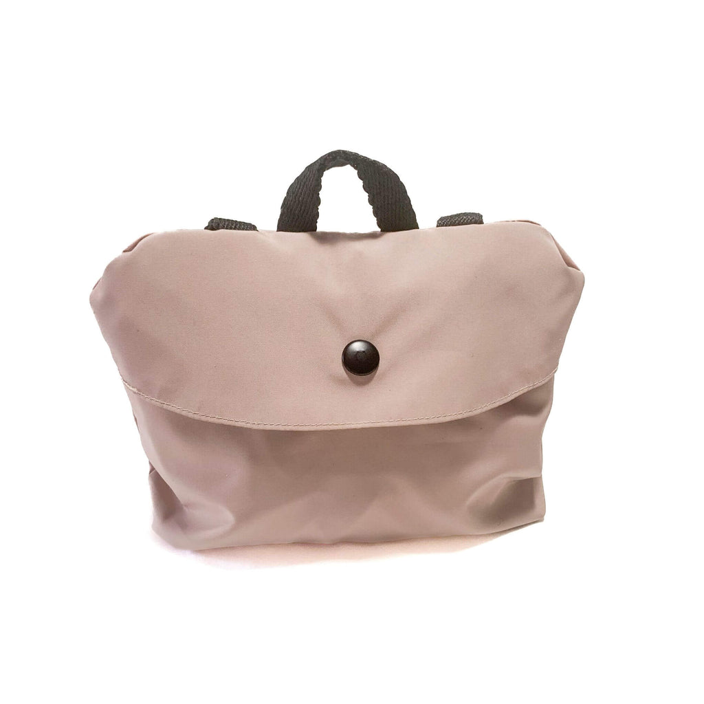 Pale Blush packable dog raincoat shown packed into backpack carrying case. Case features a black recycled polyester locker loop and a matte black snap closure.