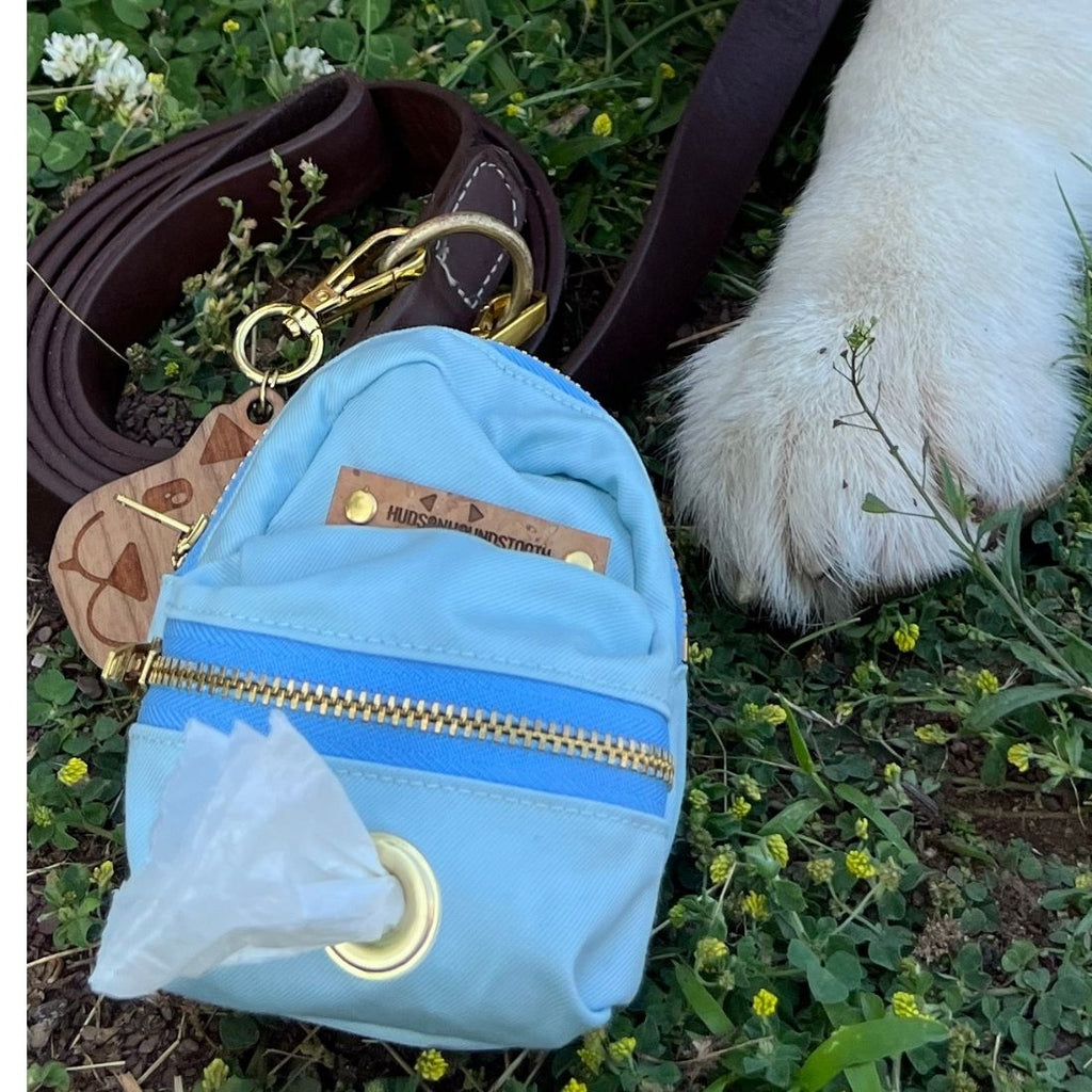 Aqua Twill Dog Backpack Waste bag and treat dispenser shown attached to leash by brass hardware. Backpack includes peri YKK zipper and brass grommet for dispensing dog poop bags on front pocket.